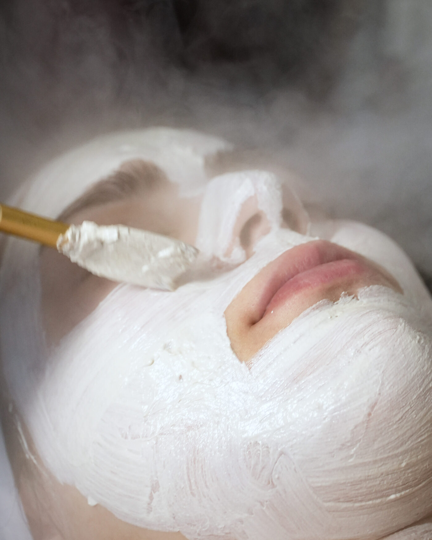 A clay mask applied under steam during a facial at NKD SKN