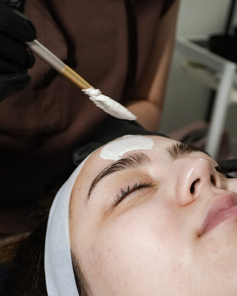A mask being brushed across the forehead during a facial